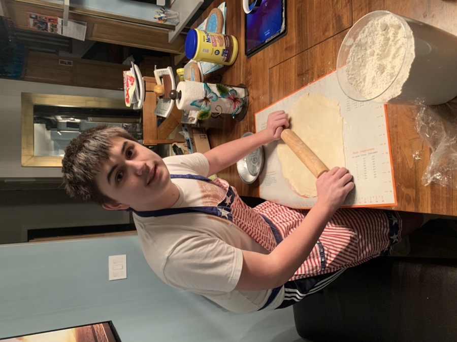 Chris rolling out dough in an apron